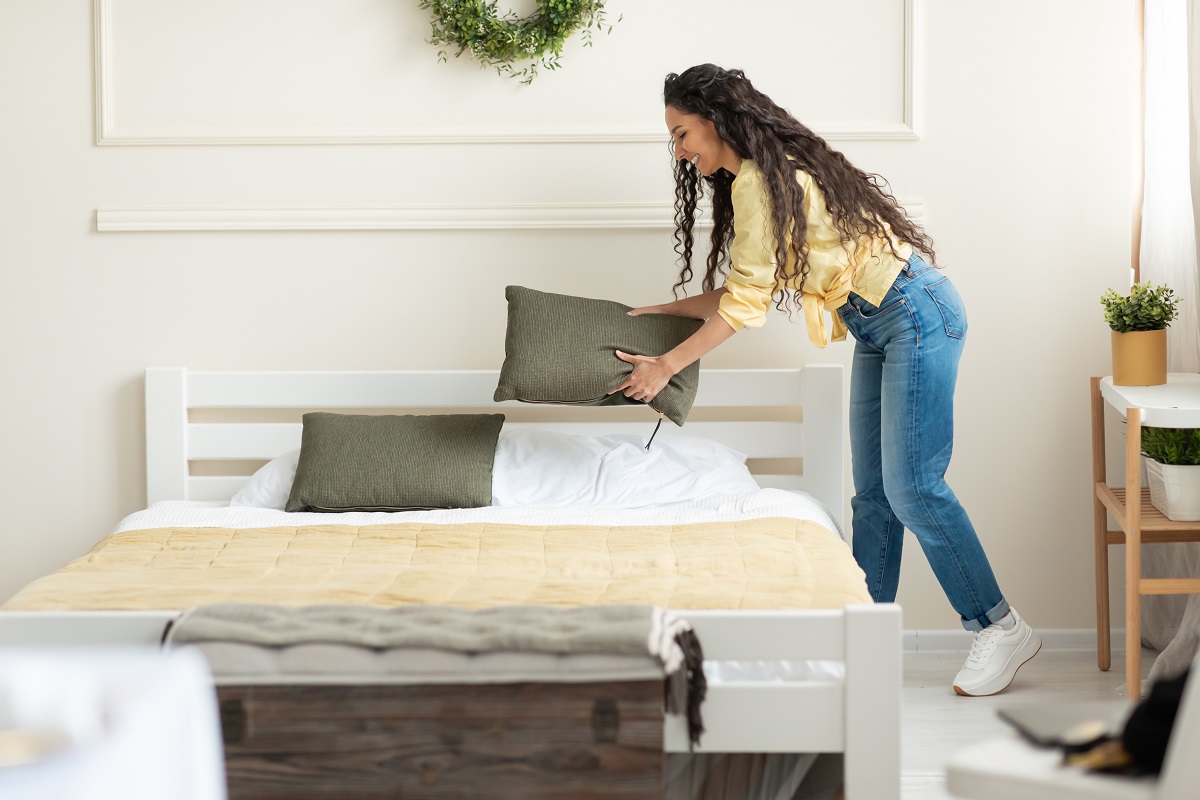Mulher arrumando sua cama Mulher arrumando sua cama